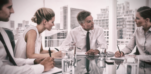 Four business professionals are talking in a board room