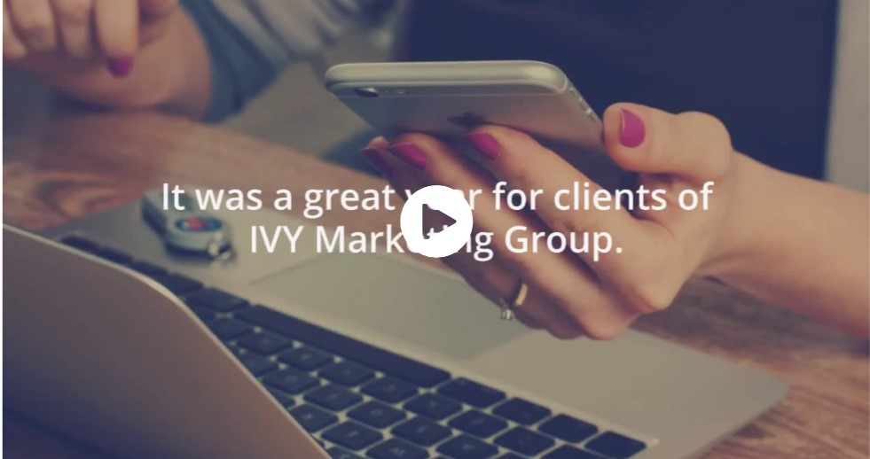 Hands holding a cell phone and near a computer are featured with a video arrow and the words "It was a great year for clients of IVY Marketing Group."