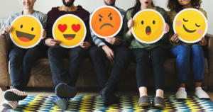 a group of people sitting and holding social media emojis